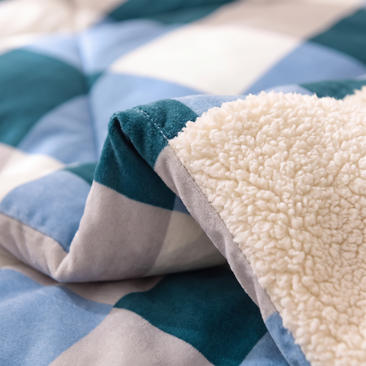 Close-up of the Blue Check quilt: teal and blue check velvet meeting thick cream sherpa fleece